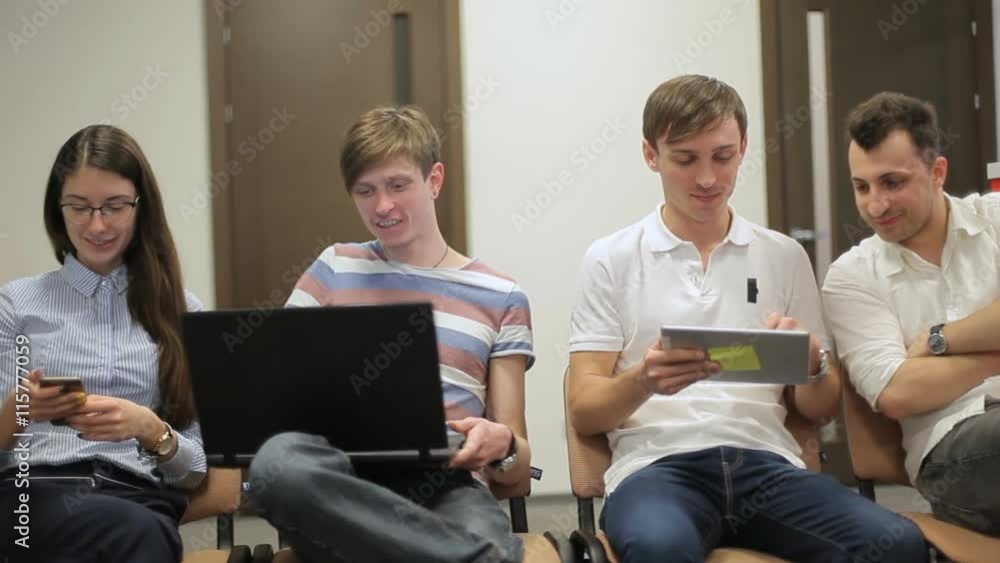 The young people sitting on the chair in the office The young people sitting on the chair in the office
