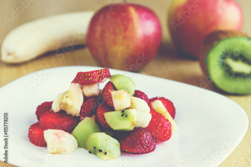 Healthy fruit salad with chocolate and yougurt in white dish. Healthy breakfast, weight loss concept