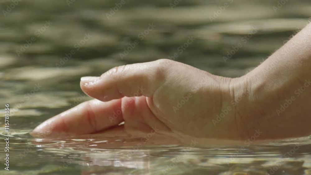 SLOW MOTION CLOSE UP: Female hand scooping pure clean water SLOW MOTION CLOSE UP: Female hand scooping pure clean water