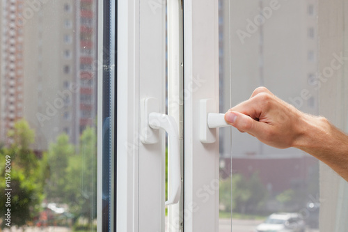 Man Hand opens a plastic pvc window photo