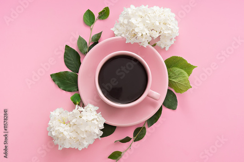 cup of coffee with flowers on pink table