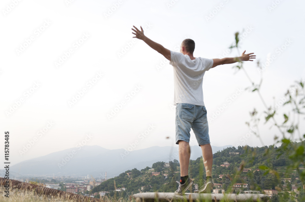 young man arms outstretched to the side at city views young man arms outstretched to the side at city views