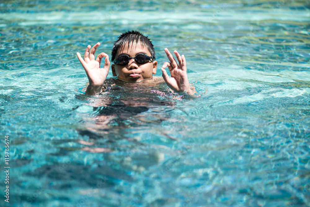 Asian boy swimming in pool on weekend