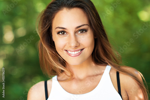 Schöne Frau lacht und ist glücklich in der Natur und zeigt ihre weißen Zähne photo