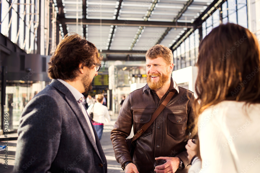 Happy businessman discussing with colleagues at railroad station Happy businessman discussing with colleagues at railroad station