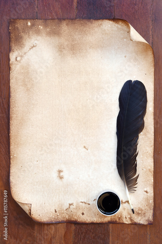old paper with feather and ink on wooden background