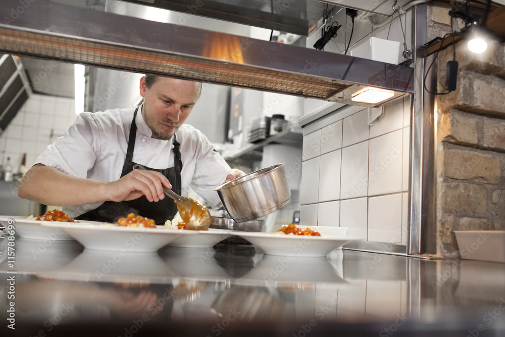 Chef serving food in restaurant kitchen Chef serving food in restaurant kitchen