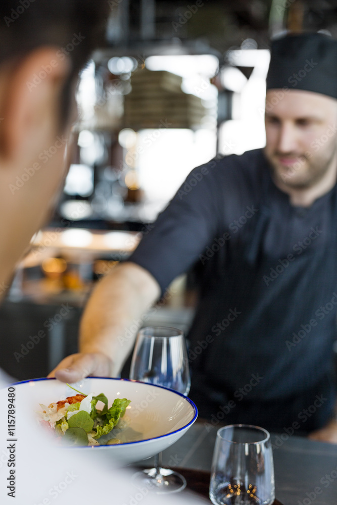 Chef serving dish to customer at Sky bar restaurant Chef serving dish to customer at Sky bar restaurant