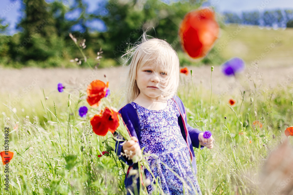 Girl holding poppy flowers at grassy field Girl holding poppy flowers at grassy field