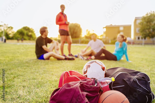 Basketball players walking with bicycles on sidewalk at park