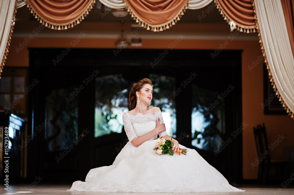Portrait of beautiful bride at wedding hall background curtains