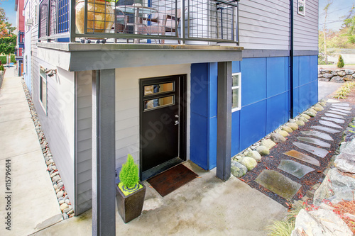 Black entrance door of modernized apartment with natural stone walkway. photo