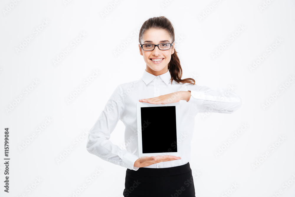 Happy pretty young businesswoman in glasses holding blank screen tablet