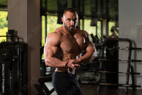 Fitness Shaped Muscle Man Posing In Dark Gym