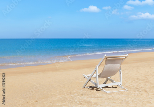 Fototapeta Naklejka Na Ścianę i Meble -  Empty white wooden beach chair on tropical beach with blue sky 