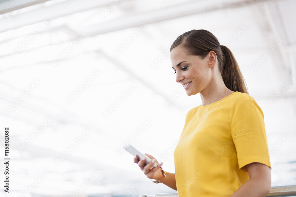 Smiling brunette woman holding cell phone Smiling brunette woman holding cell phone