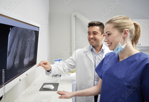 dentists with x-ray on monitor at dental clinic