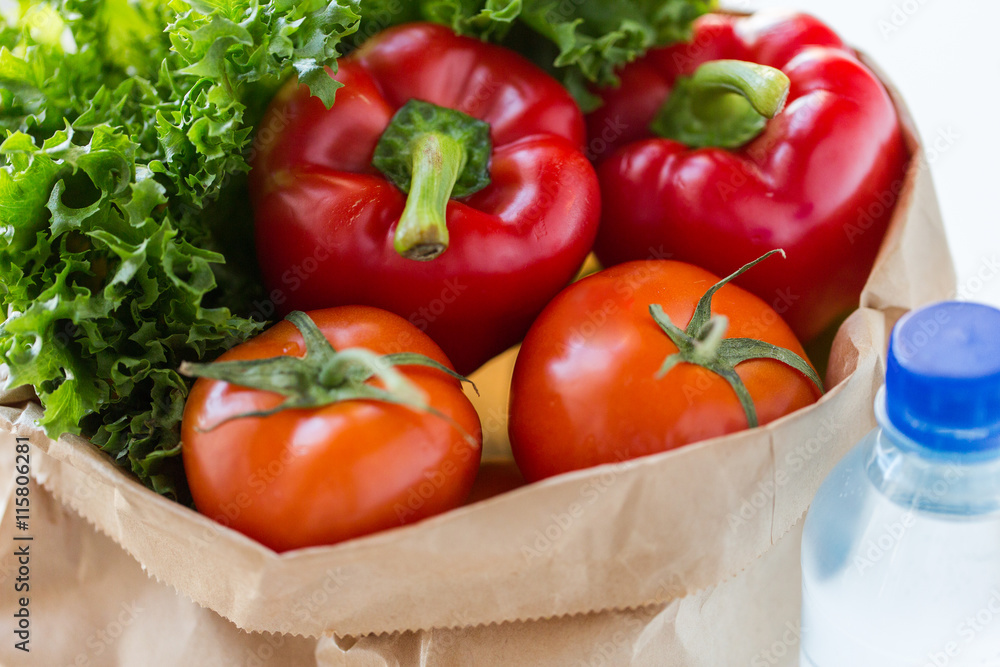 close up of paper bag with vegetables and water close up of paper bag with vegetables and water