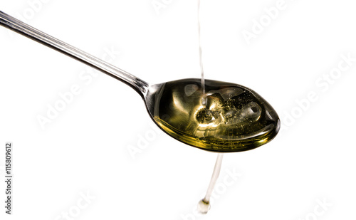 Olive oil pouring into spoon