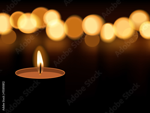 Candle light burning with candle flame bokeh on dark background