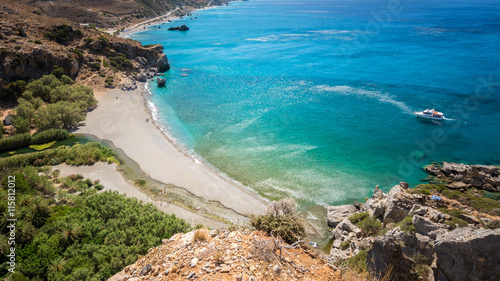 Preveli Beach na wyspie Krecie, Grecja. W pobliżu wąwozu w pobliżu plaży znajduje się las palmowy i rzeka.