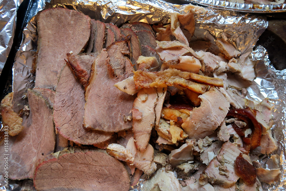 Slices of cooked Beef and Pork laying on tin foil ready to be served for dinner Slices of cooked Beef and Pork laying on tin foil ready to be served for dinner