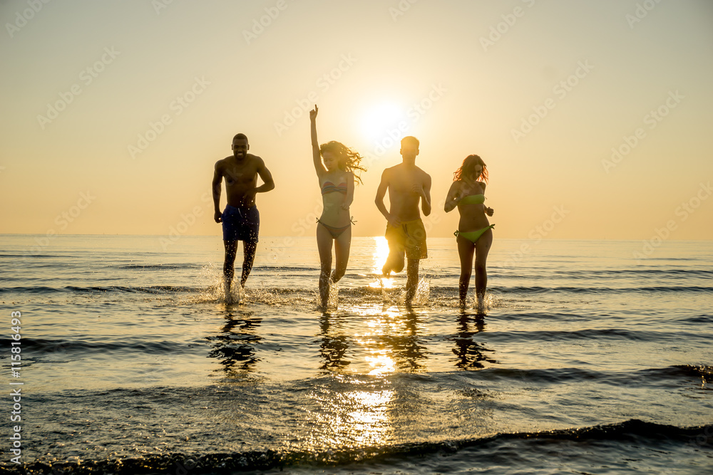 group of friends on beach sunset silhouette