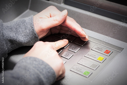 Woman's hand covers his hand when entering your PIN into an ATM