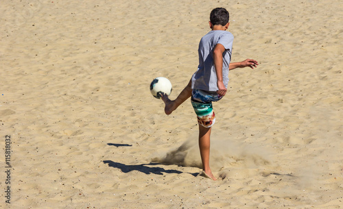 Fotografia Menino chutando a bola.