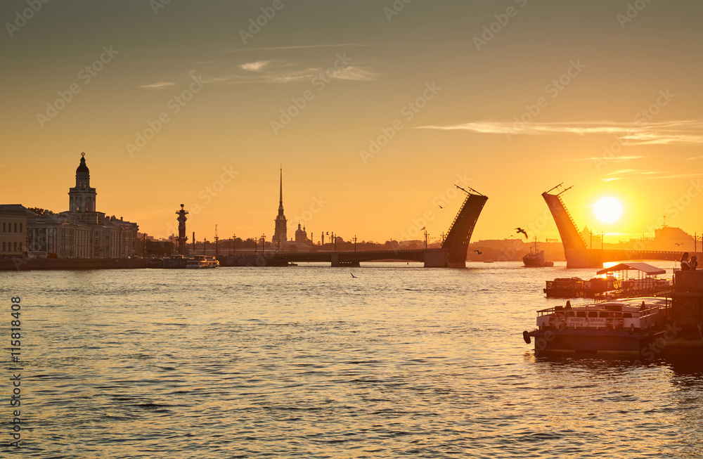 Naklejka premium Russia, Saint-Petersburg, 03 July 2016: Closing of Palace Bridge at sunrise, the Peter and Paul Fortress Spike in the orange sky, Rostral colomn, ships, boats, the traffic beginning, sun, 