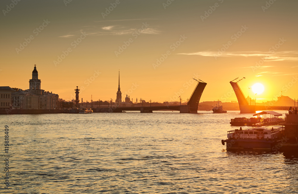 Naklejka premium Russia, Saint-Petersburg, 03 July 2016: Closing of Palace Bridge at sunrise, the Peter and Paul Fortress Spike in the orange sky, Rostral colomn, ships, boats, the traffic beginning, sun, 