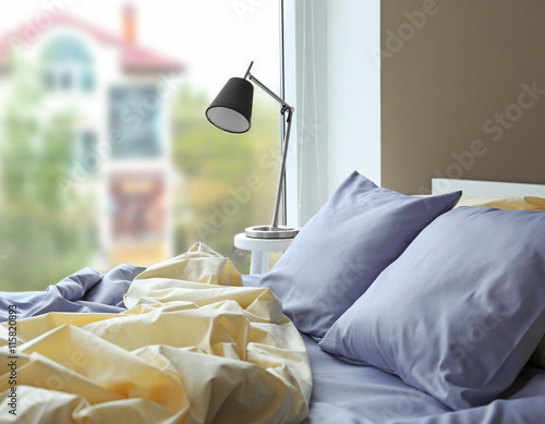 Unmade bed with crumpled bl...