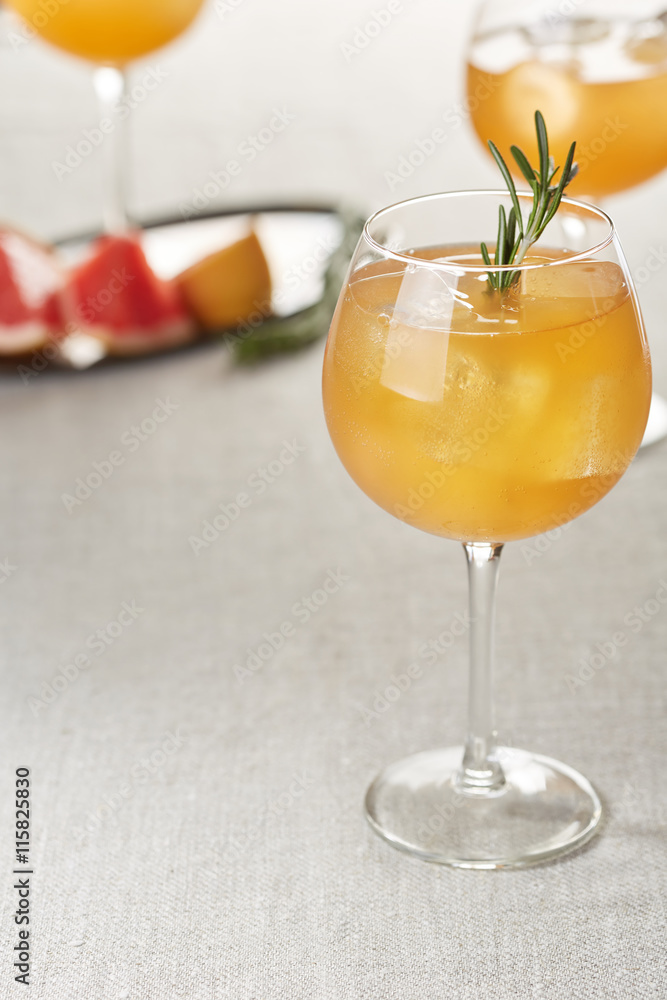 wine glasses of grapefruit juice with ice cubes and rosemary