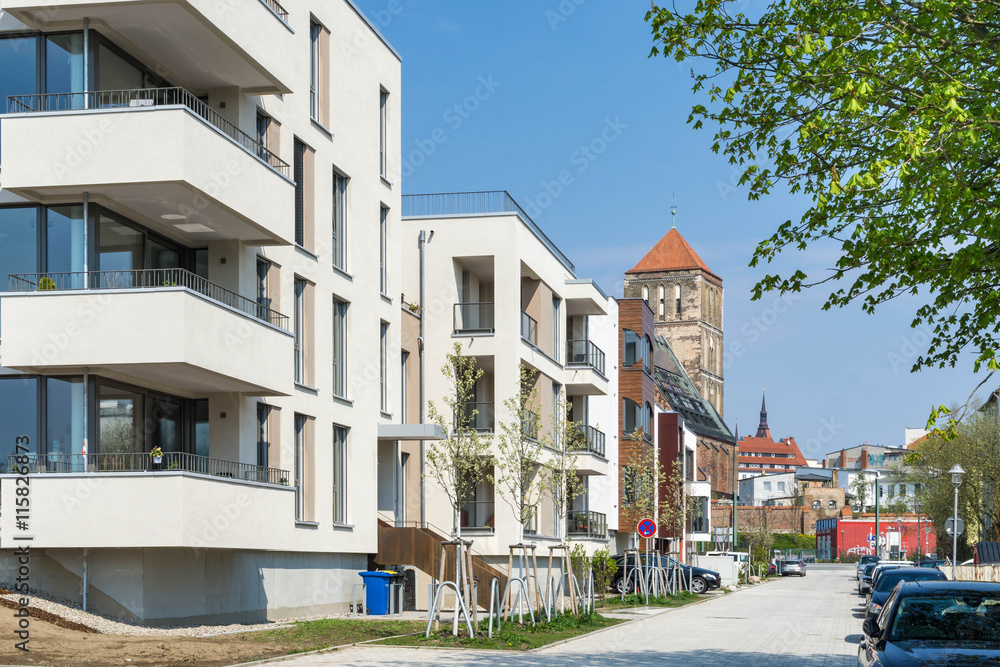 Fototapeta premium Nowoczesne kamienice z kościołem w tle