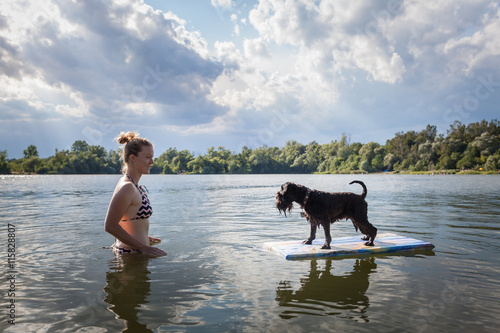 Dog on a float with his owner in lake water