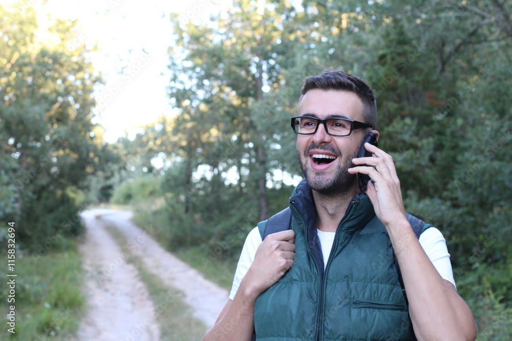 Handsome man with glasses phoning in the park. Beautiful man with hand on the face Handsome man with glasses phoning in the park. Beautiful man with hand on the face