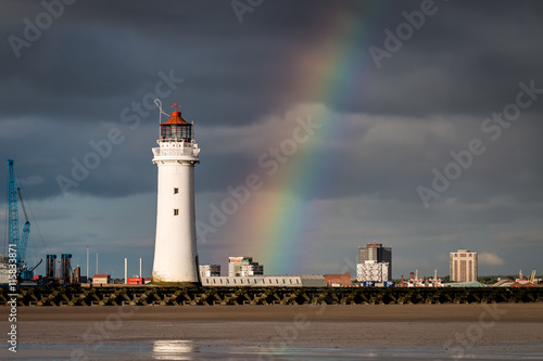 Perch Rock lighthouse at New Brighton near Liverpool with dark clouds and a rainbow photo