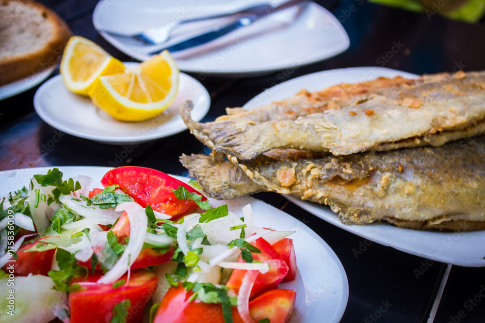 fried fish with fresh herbs and lemon