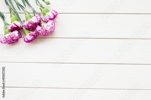 Pink carnations on wooden background