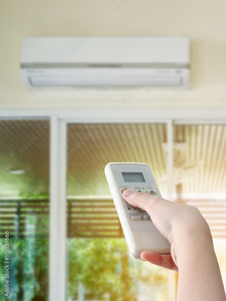 Hand hold remote control directed on the air conditioner Hand hold remote control directed on the air conditioner