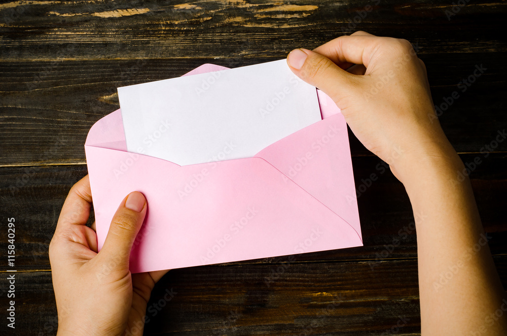 Pink envelope and blank white card holding by hand Pink envelope and blank white card holding by hand