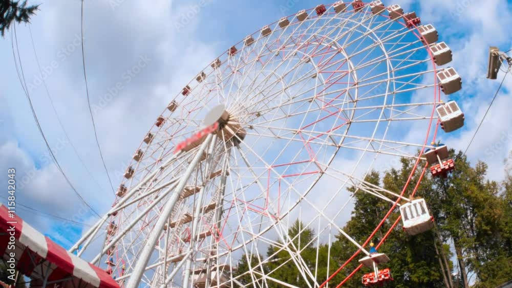 Ferris wheel in the amusement park against the backdrop of running thick clouds Ferris wheel in the amusement park against the backdrop of running thick clouds