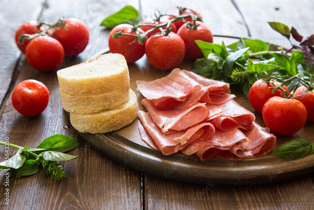 Antipasto with ham and bresaola. tomato and basil. 