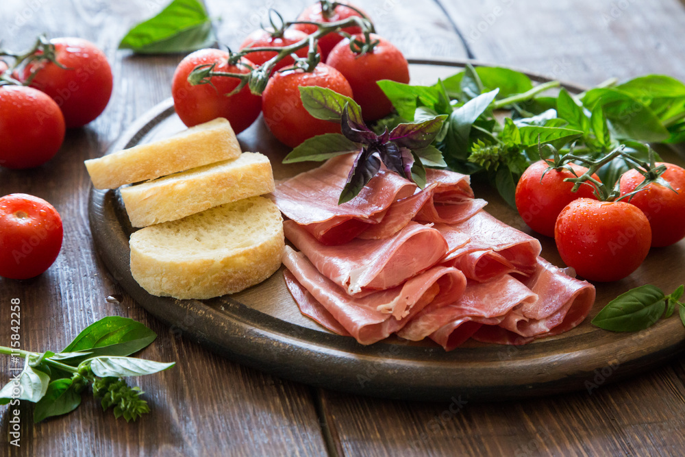 Antipasto with ham and bresaola. tomato and basil. Antipasto with ham and bresaola. tomato and basil.