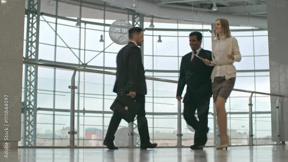 Businessmen and businesswomen in formal suits walking in the office center Businessmen and businesswomen in formal suits walking in the office center