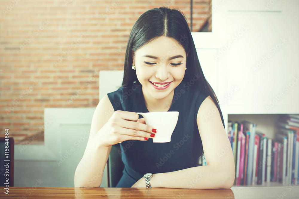 Asian Woman drinking coffee with smile on her face in vintage tone Asian Woman drinking coffee with smile on her face in vintage tone
