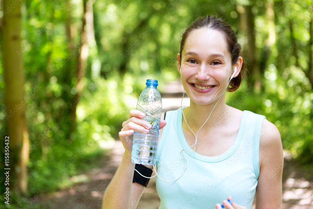 Young attractive woman drinking water after a running session Young attractive woman drinking water after a running session