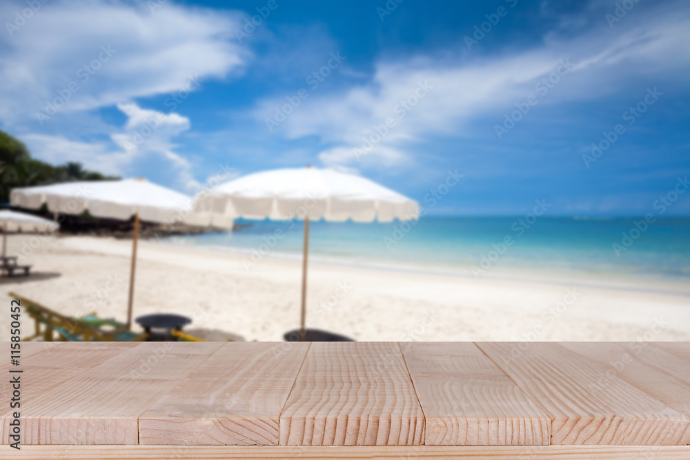 Wood table top on blurred blue sea and white sand beach backgrou Wood table top on blurred blue sea and white sand beach backgrou
