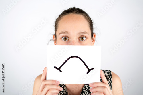 Sad woman hidden behind a board isolated on a white background