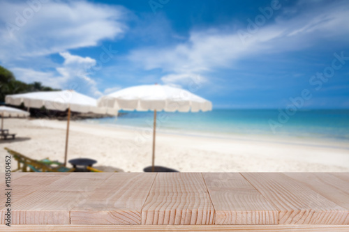 Wood table top on blurred blue sea and white sand beach backgrou © sripfoto